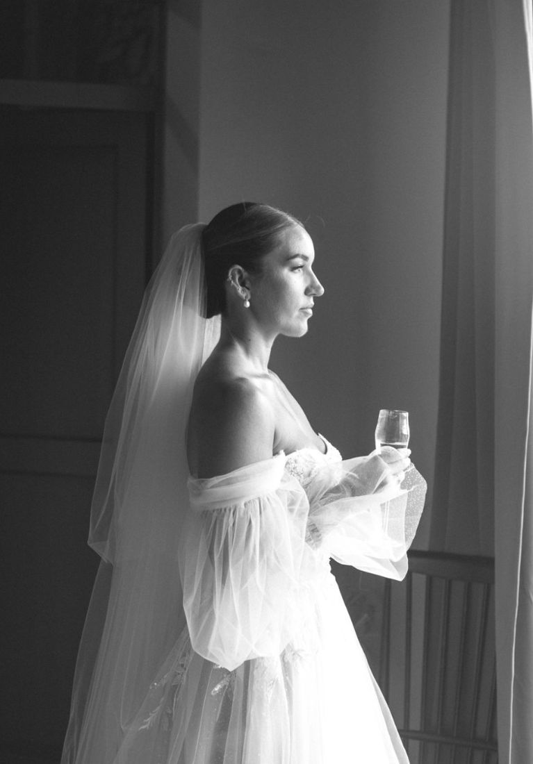 Bride by a window holding a glass